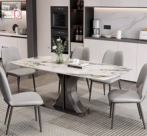 Elena dining table with marble top and curved metal base paired with gray upholstered chairs for stylish dining space