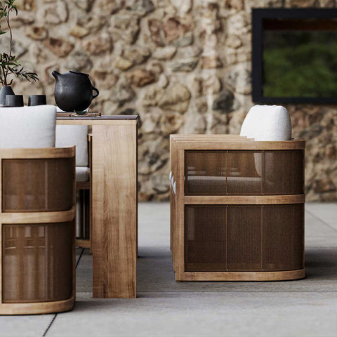Modern outdoor armchair with cylindrical wooden frame white cushions and woven bamboo sides for eliza rttan outdoor dining table