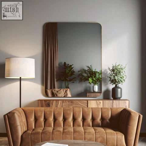 Brown tufted leather sofa with the ella gold wall mirror above featuring a stylish gold wall mirror design