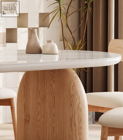 Modern oval ellison dining table with sleek white sintered stone top and rounded light wood base