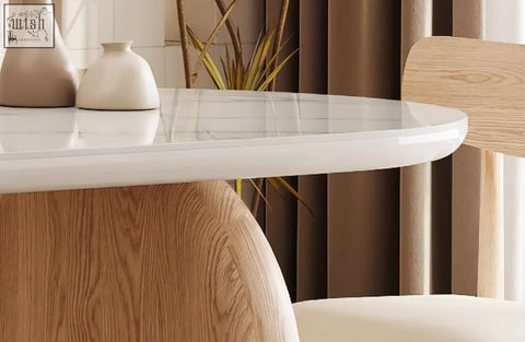 A sleek white marble top ellison modern dining table with rounded edges and a natural wood sintered stone base