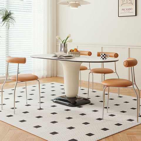 Elmer dining table with sleek white marble oval top and curved cream-colored pedestal base for modern dining