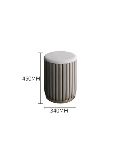 Gray cylindrical ottoman with vertical ribbed texture and gold base as part of elmore dressing table set