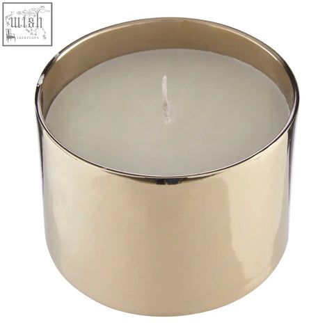A sleek elva white large gold upper candle in a metallic container with a smooth reflective surface