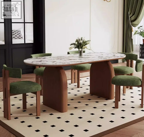 Modern emerson dining table with white marble top and brown wooden legs surrounded by green velvet chairs