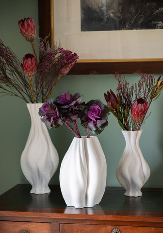 Three white ceramic vases with twisted ribbed surfaces in the emilie white twisted ceramic vase collection