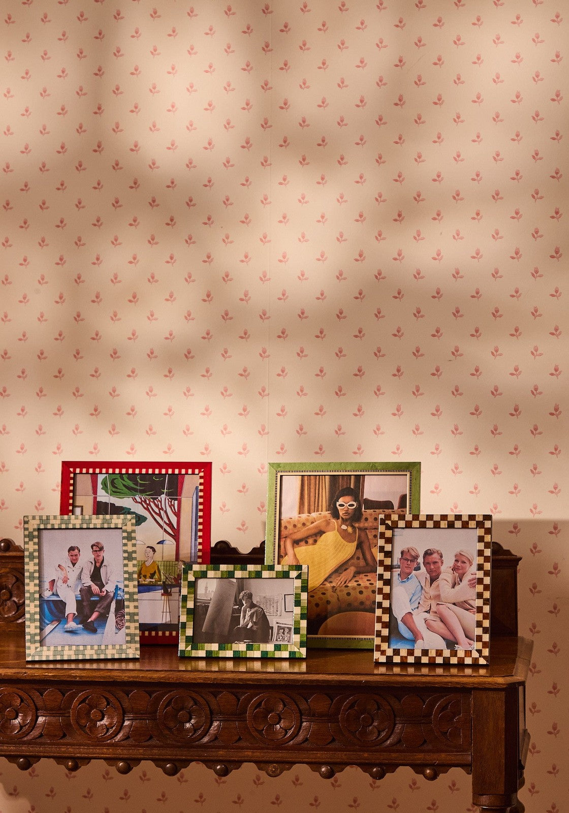 A set of five jade marquetry frames with checkered and solid-colored borders showcasing various photos for wall and desk display