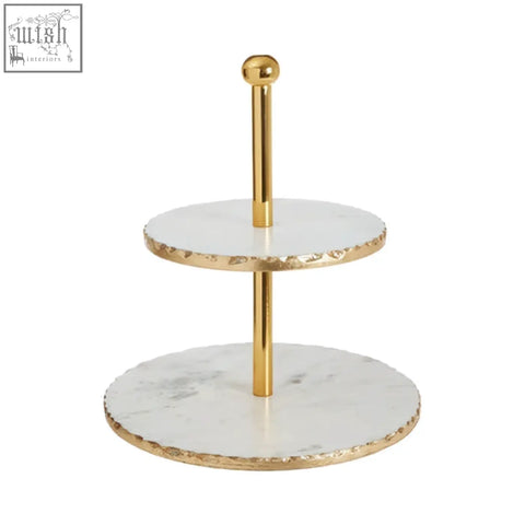 Gold finish cake stand with two white marble tiers featuring textured edges and subtle gray veining in empire style