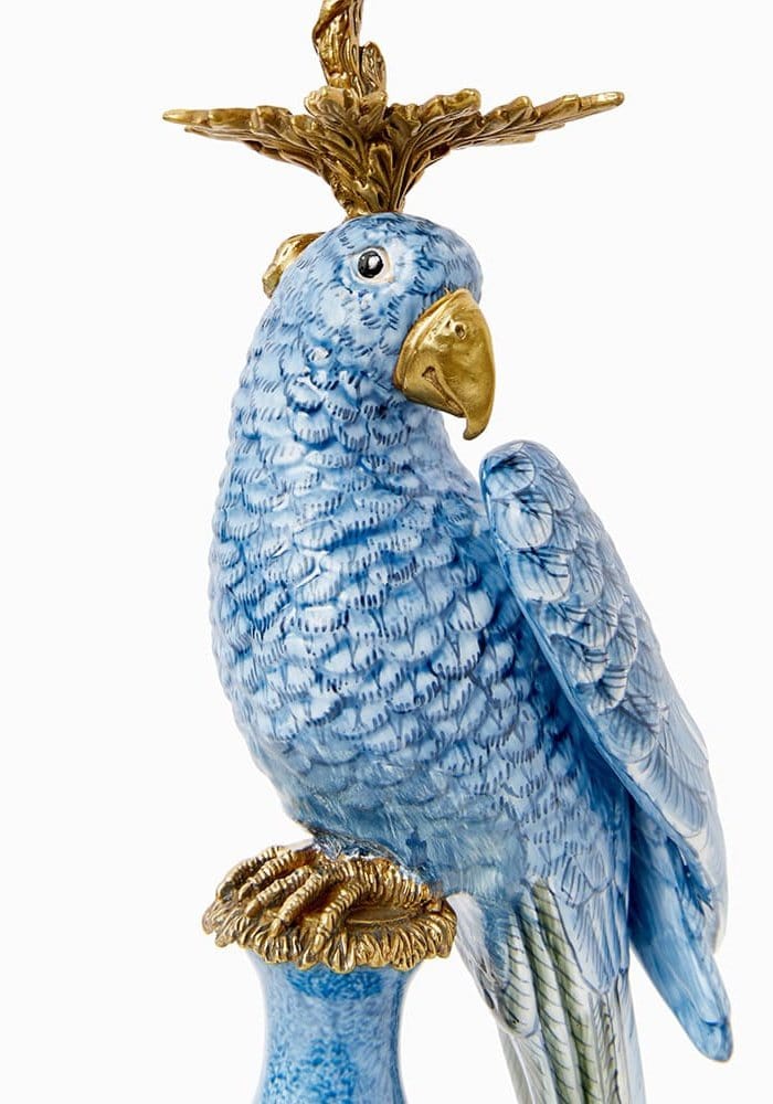 A blue porcelain enamelled pretty polly parrot candlestick with gold accents on beak feet and crest facing right