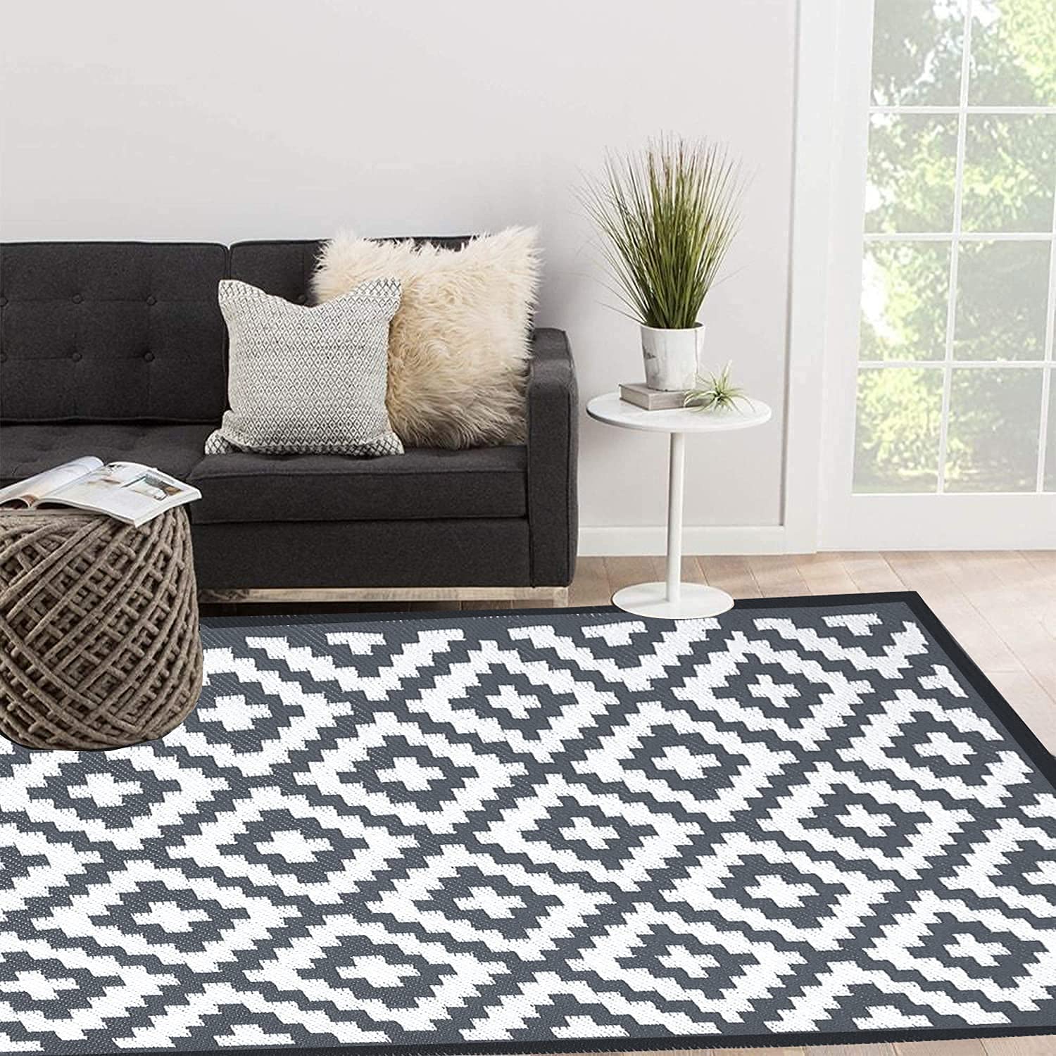 Black and white enipate geometric outdoor rug with nylon corner loops to reduce slippery accidents and prevent fraying