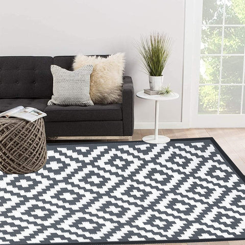 Black and white enipate geometric outdoor rug with nylon corner loops to reduce slippery accidents and prevent fraying