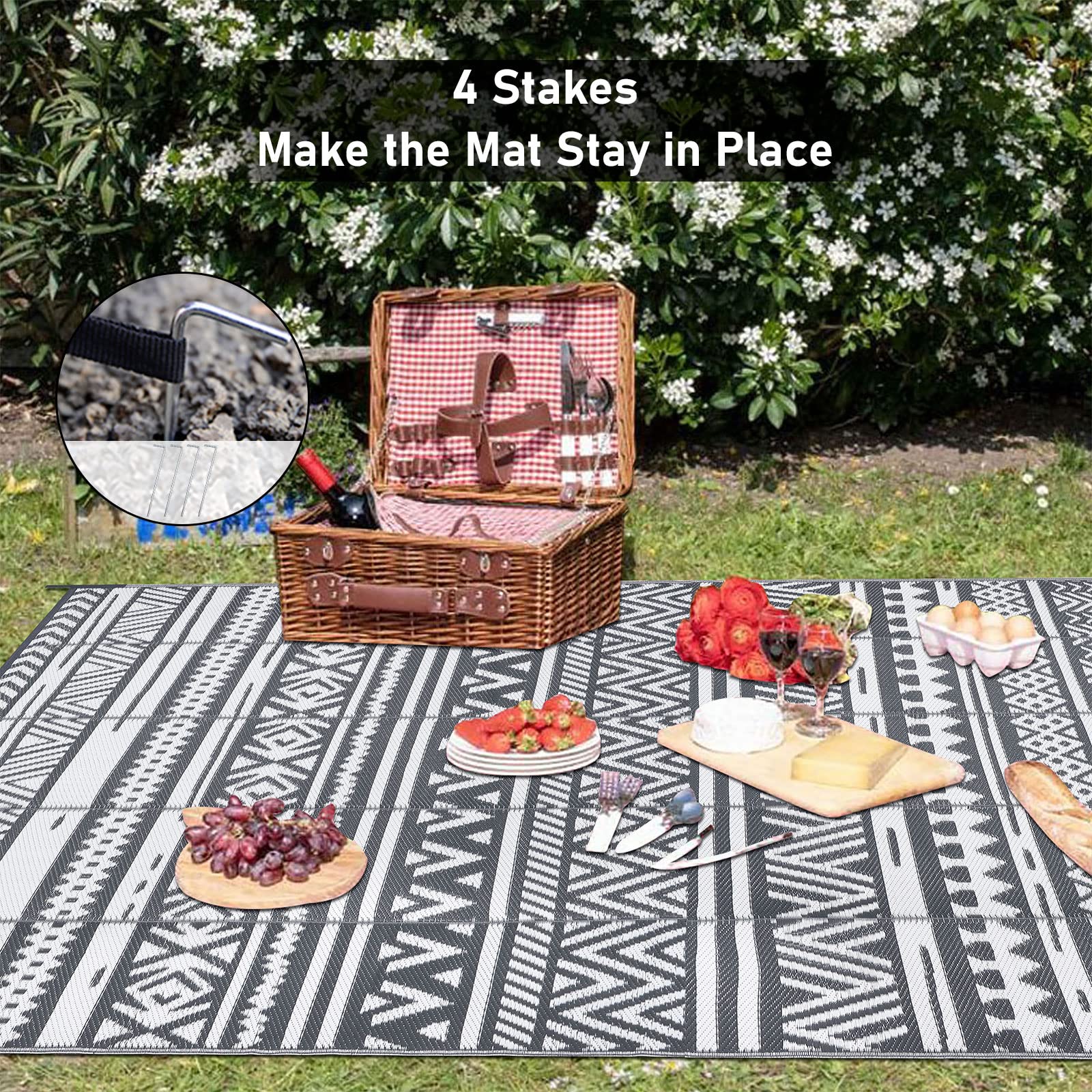 Black and white geometric patterned enyhom large grey outdoor rug with four stakes for securing on outdoor patio or lawn