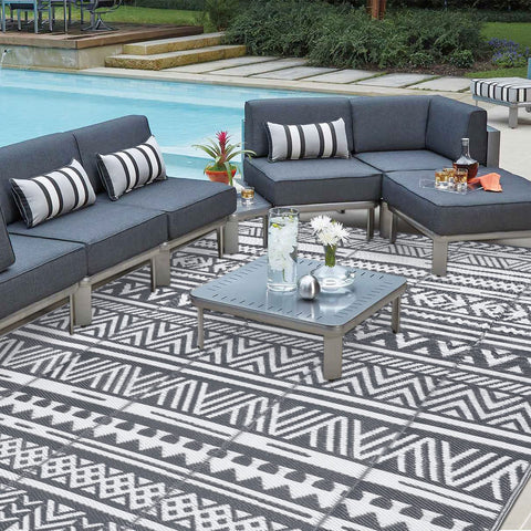 Black and white geometric pattern on enyhom large grey outdoor rug made of durable plastic straw for outdoor patio use