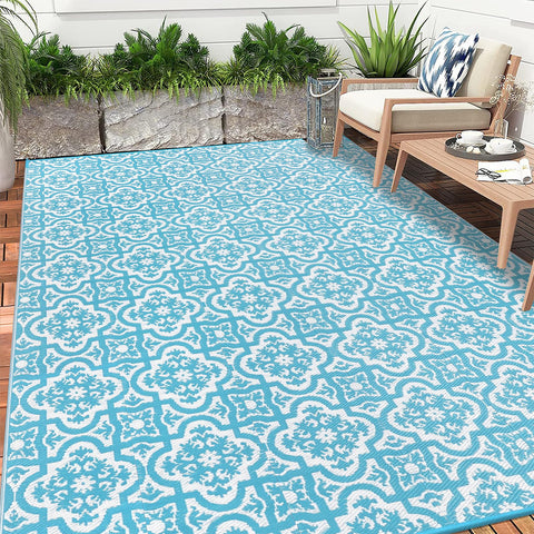 Turquoise and white patterned reversible outdoor rug made of plastic straw for garden patio and camping use