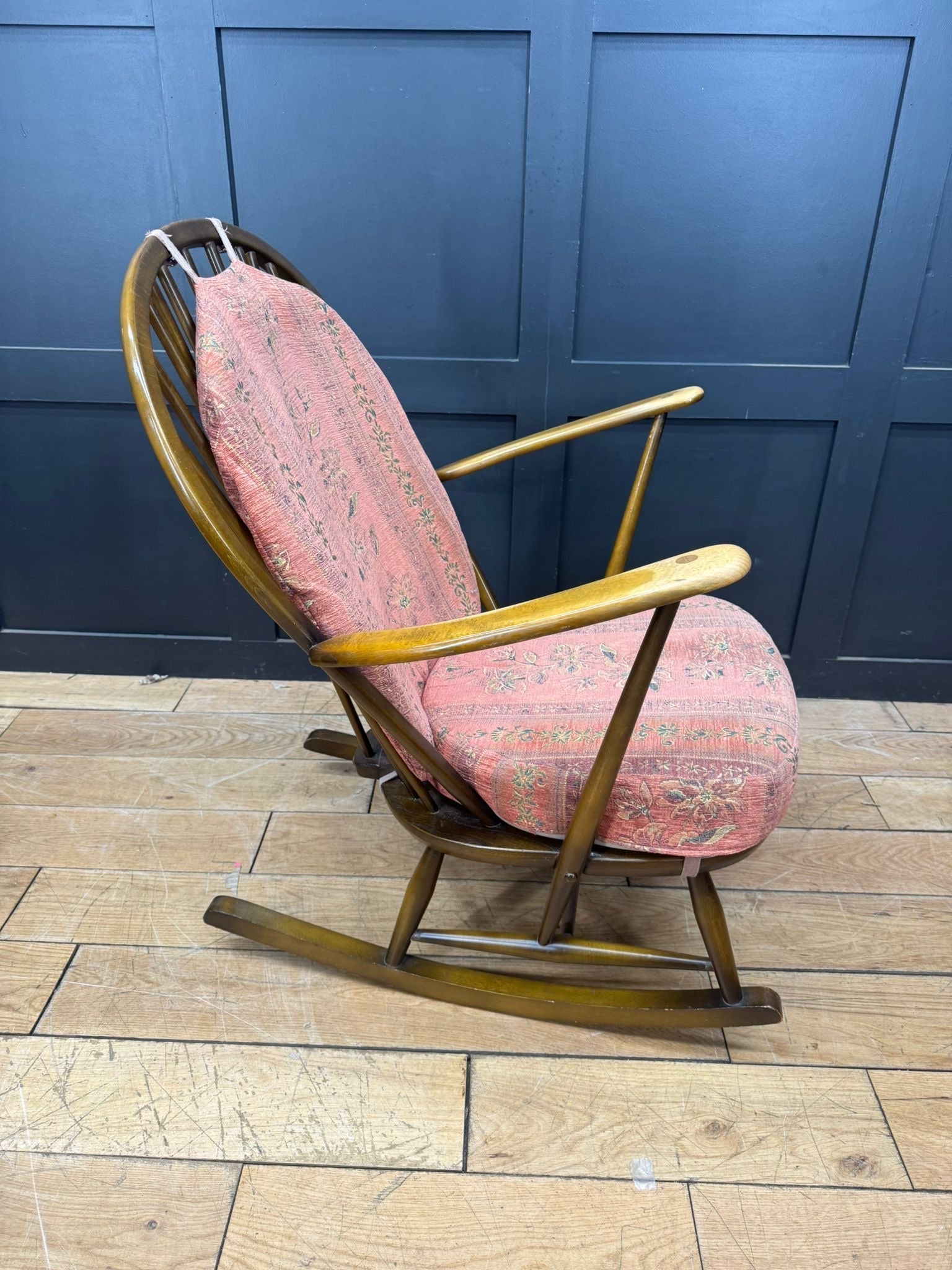 Vintage ercol grandfather rocking chair model 315 with curved wooden frame and soft pink floral cushions