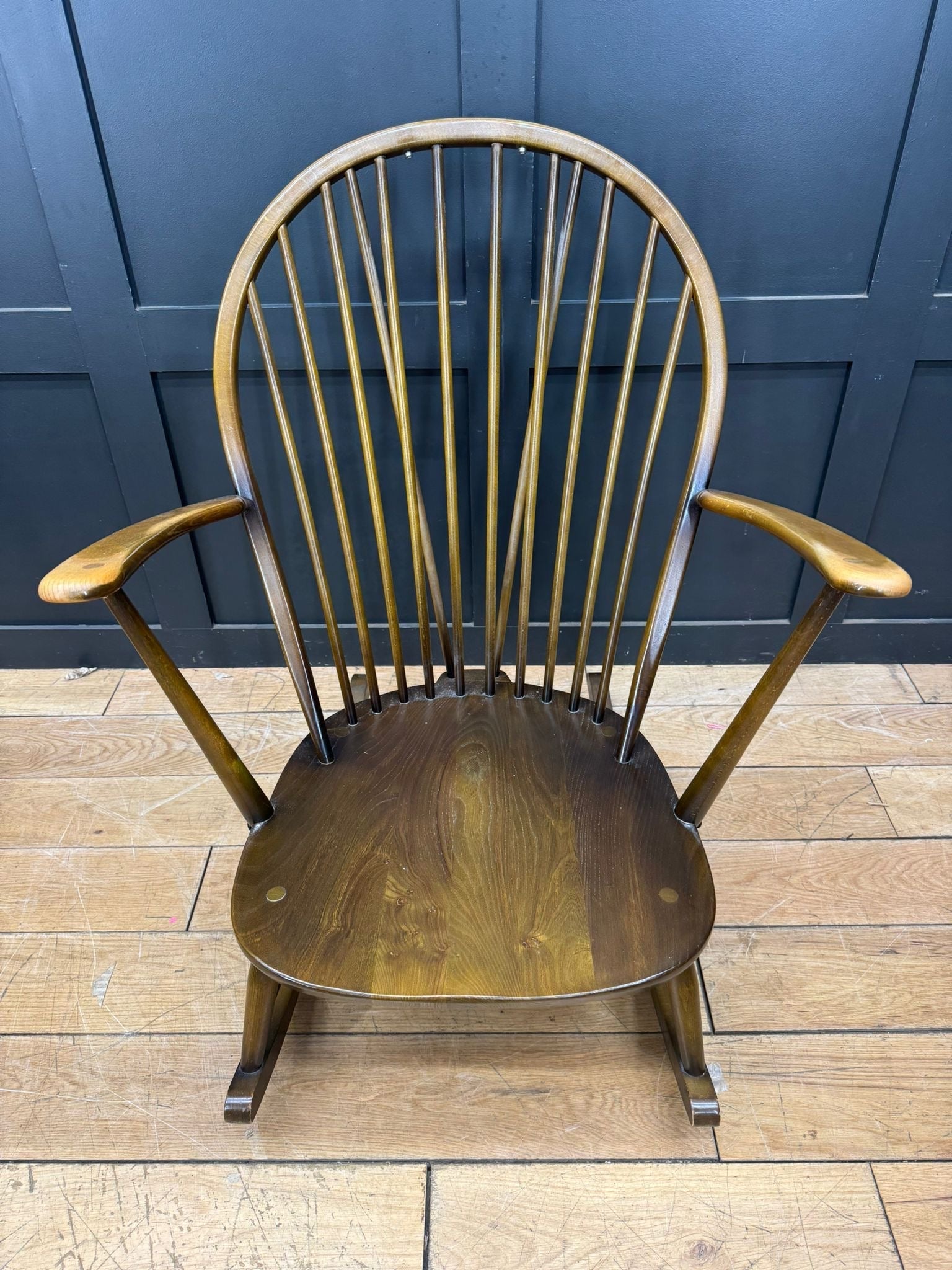 Classic wooden ercol grandfather rocking chair model 315 with warm finish and arched spindle backrest