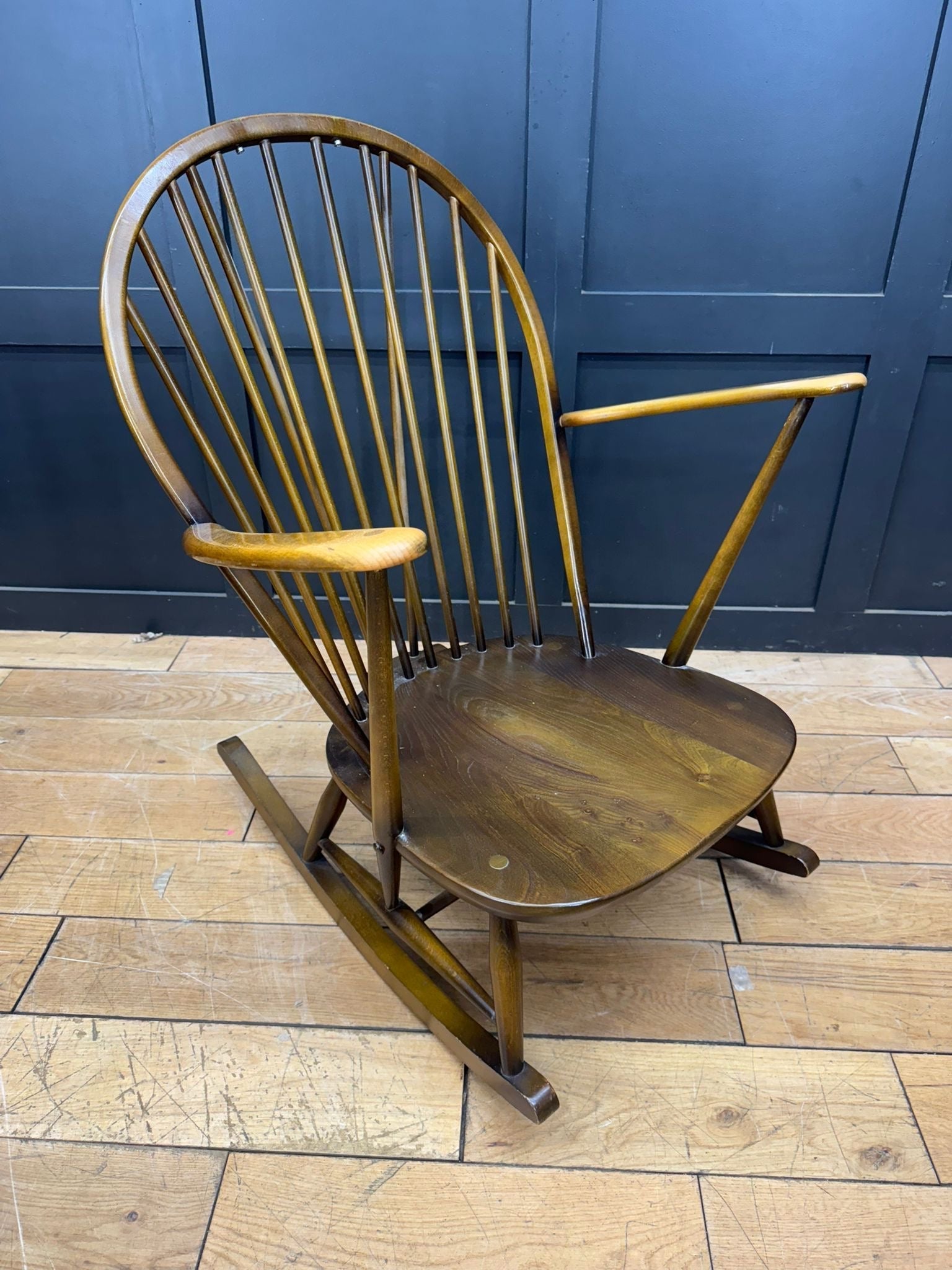 A classic ercol grandfather rocking chair model 315 in warm honey-brown wood with curved back and original cushions