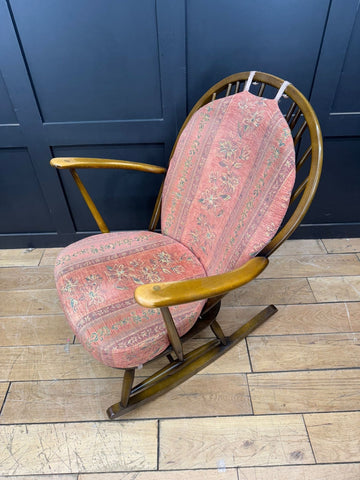 Vintage-style ercol grandfather rocking chair model 315 with pink floral upholstery and wooden curved armrests