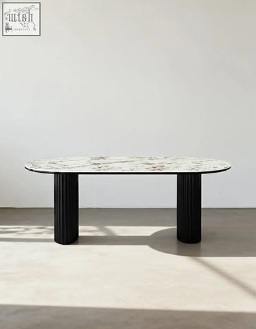 Elegant escobar dining table with oval marble top and sleek black fluted legs perfect for stylish dining areas