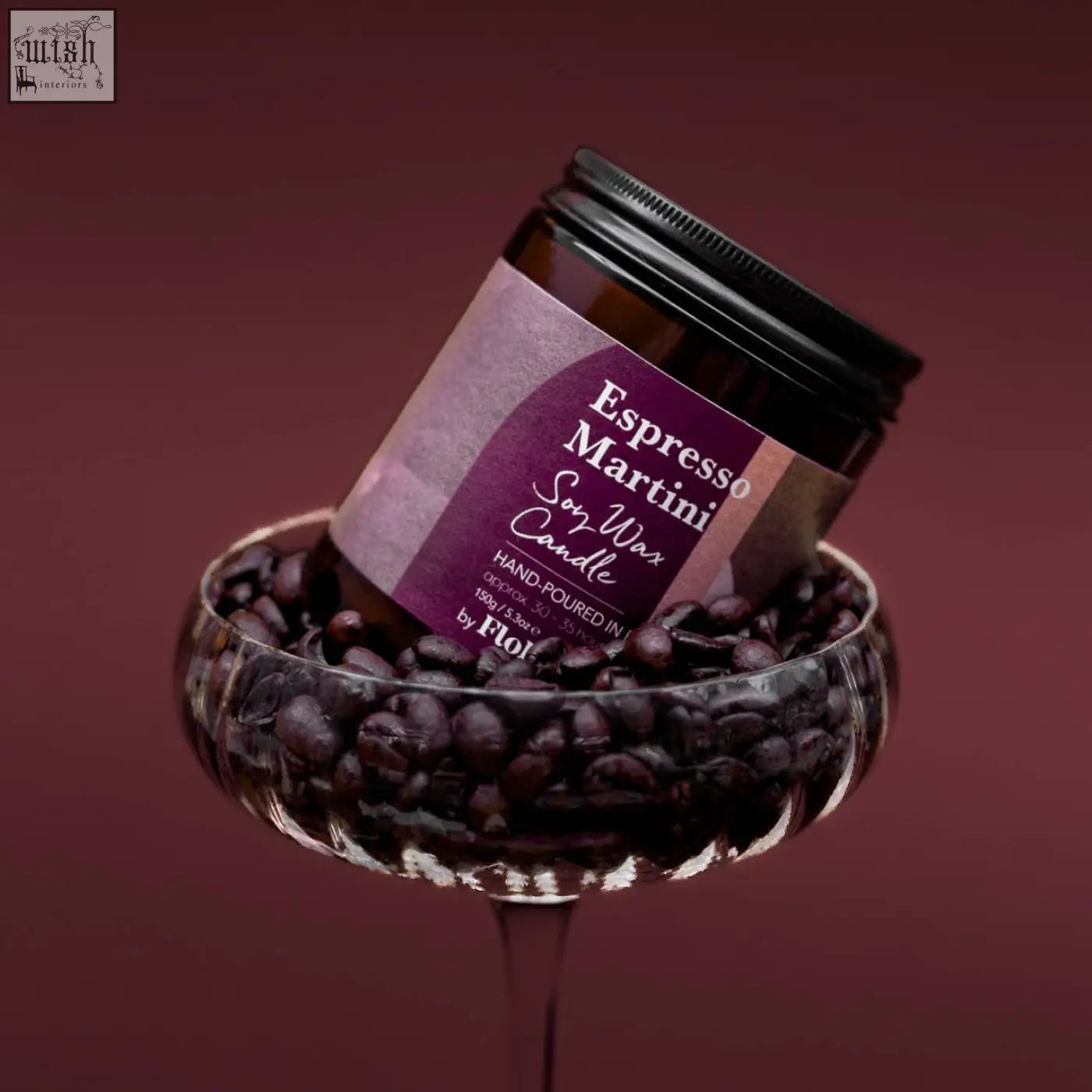A dark amber glass jar with a black lid holds an espresso martini soy wax candle by flor sustainably sourced