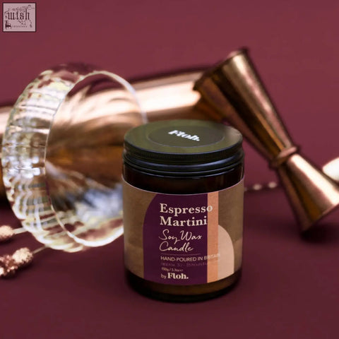 A dark amber glass jar soy wax espresso martini candle by floh with a matte black lid and purple beige label sustainably sourced