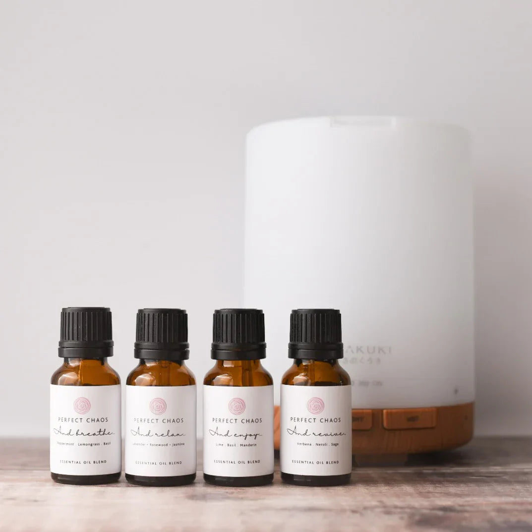 Four amber glass essential oil bottles with black caps and perfect chaos labels highlighting quick shipping times