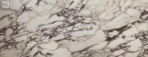 Esther oval dining table with black and white marble sintered stone countertop featuring natural swirling veins