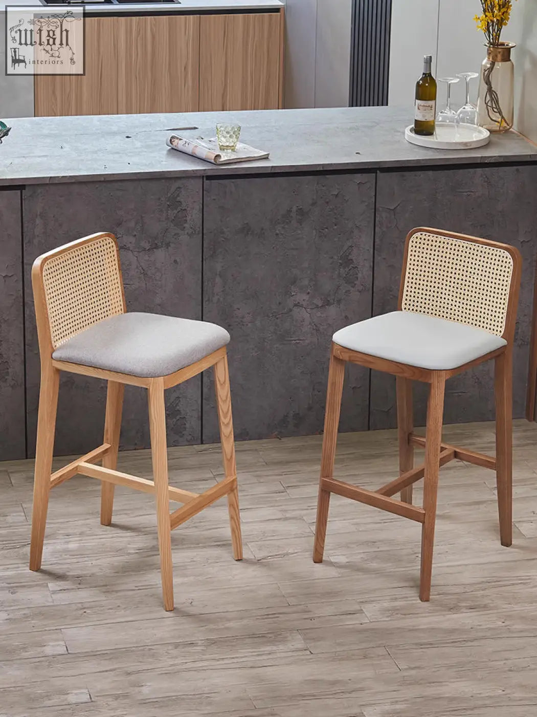 Two ethan rattan barstools with light wood frames, woven cane backs, and gray seats perfect for coffee table set areas
