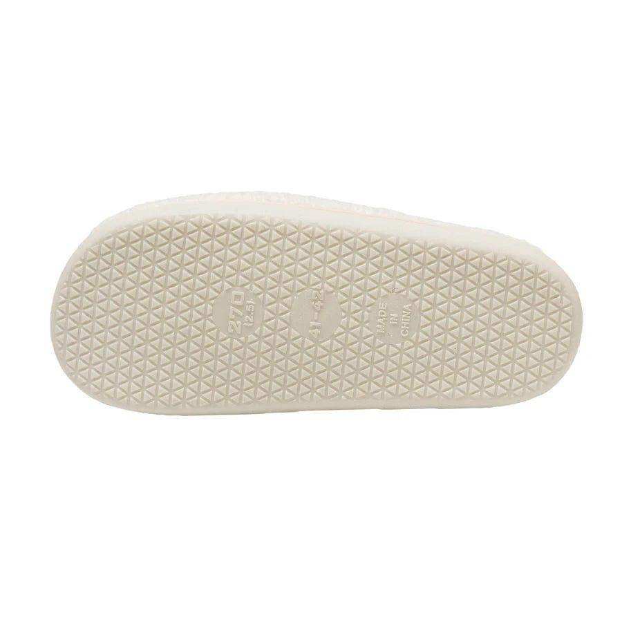 Off-white rubber sole of euphoria slippers with textured triangular pattern and embossed smiley face brand markings to stay warm