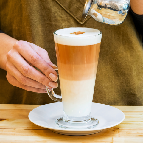 A tall clear glass latte cup from euri latte glasses set of 4 filled with layered coffee and milk foam
