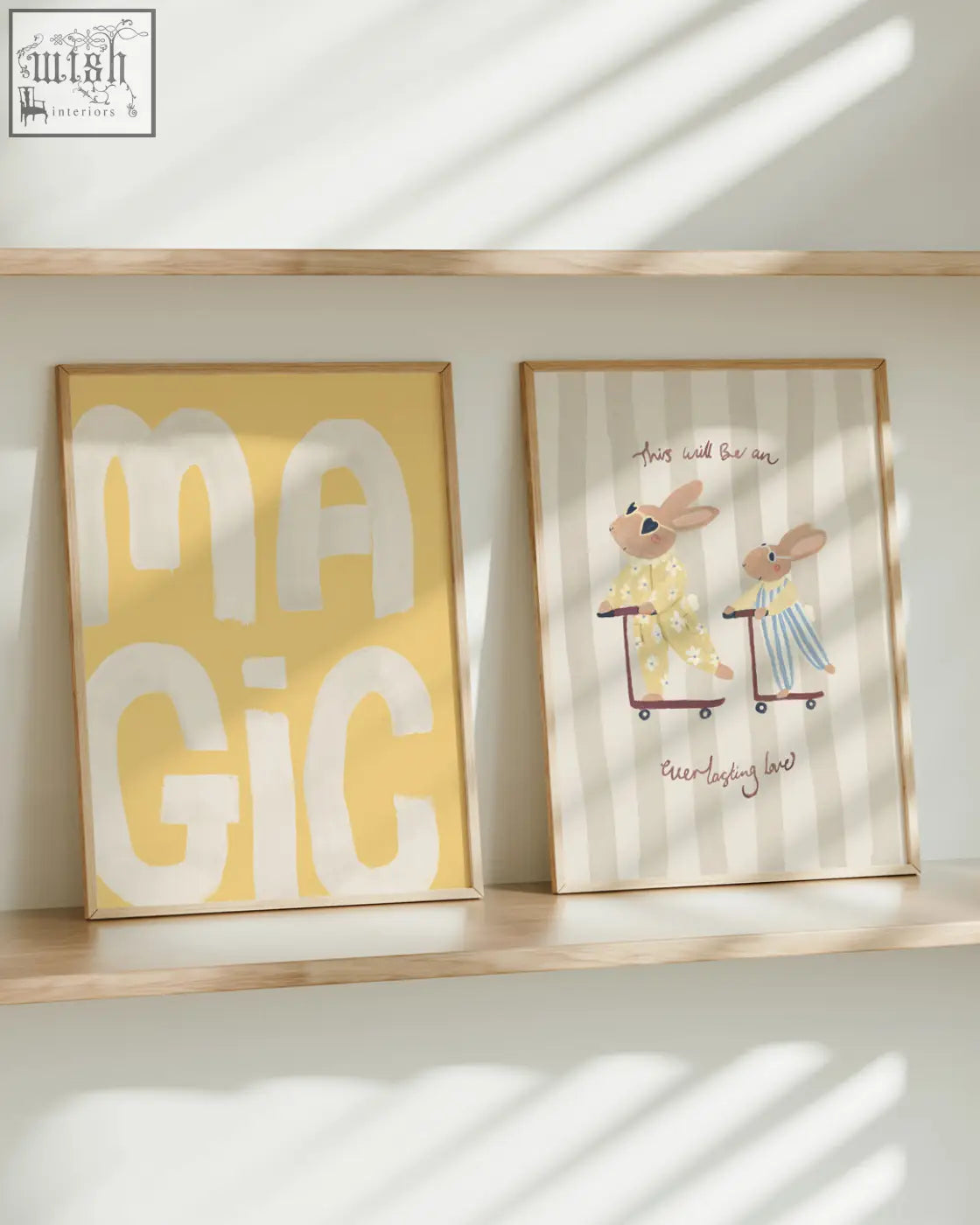 Two framed art prints on a wooden shelf featuring a rabbit pair with pajamas and bold white lettering on yellow background