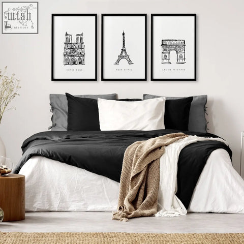 Three black-framed extra large wall art prints featuring minimalist paris landmarks above the bed