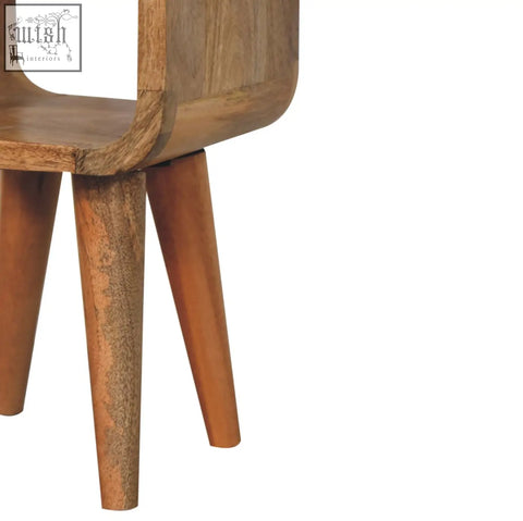 A mid-century modern extra mini minimalist open curved oak-ish wooden bedside table with an open shelf and warm finish