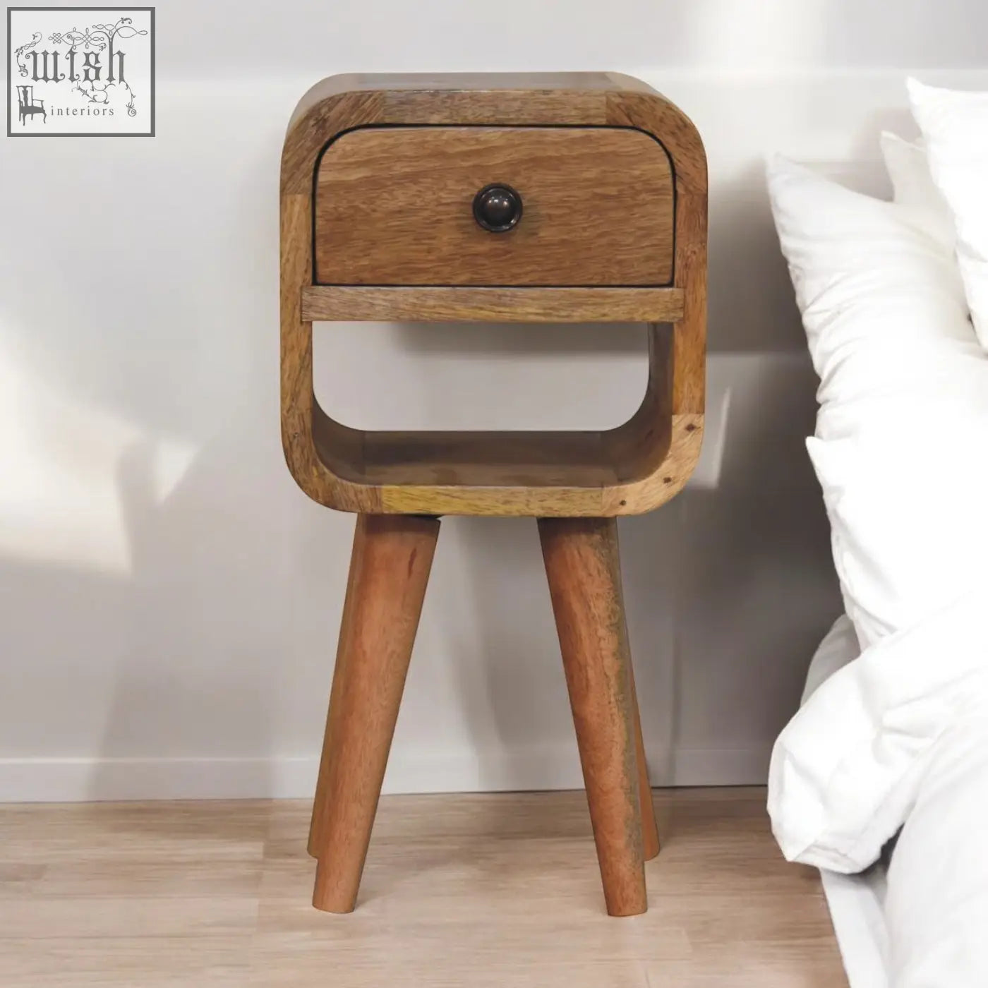 A rustic extra mini oak-ish curve lower bedside table with natural oak finish, one drawer, and dark metal knob