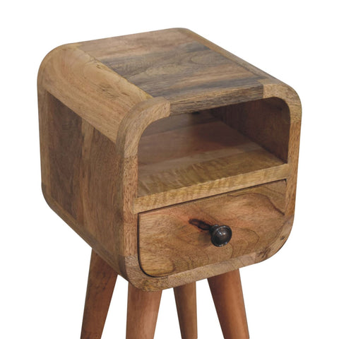 A rustic oakish open slot bedside table with a curved top, single drawer with black knob, and three tapered legs