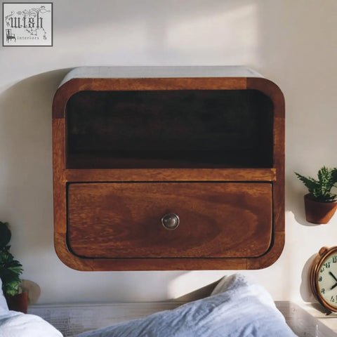 A sleek wall mounted wooden nightstand in rich brown with rounded edges made of solid mango wood