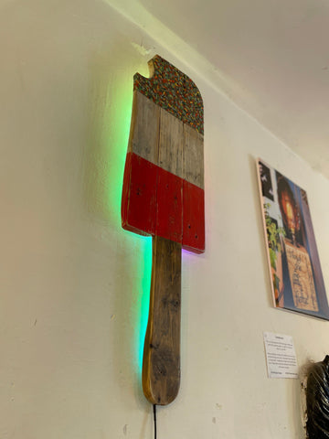 Fab lolly colour changing led wall light shaped like a red paintbrush with reclaimed wood and green glowing strip
