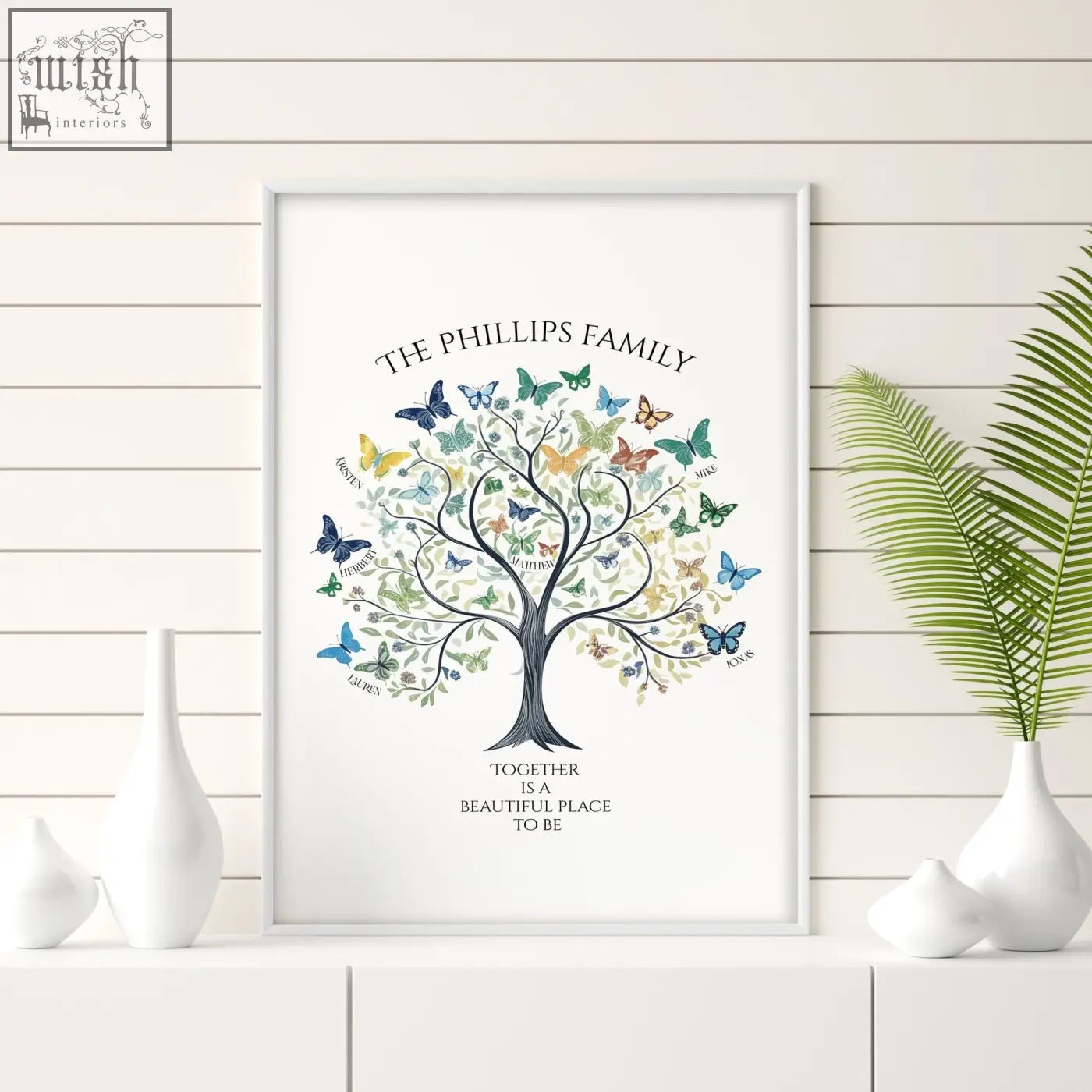 A framed family tree art print with a black tree, colorful butterflies, and names titled the phillips family wall art
