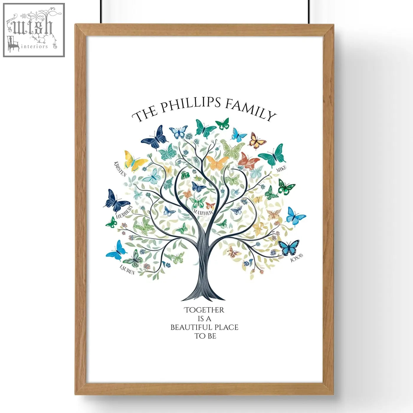 A framed family tree art print with a dark trunk and colorful butterflies in a light wood frame for wall decor