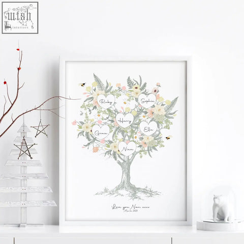A framed family tree artwork with delicate watercolor flowers greenery and heart-shaped name labels like ruby sophie harry ellie grace niam
