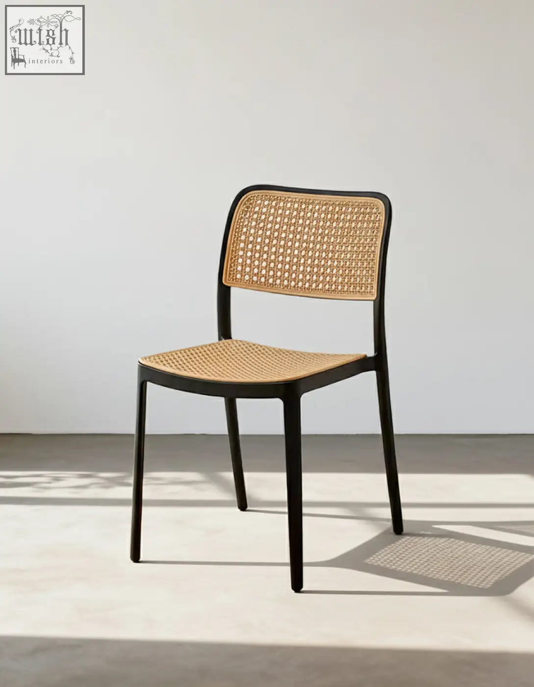 Black-framed fanny dining chair with woven cane back and seat perfect for stylish dining setups