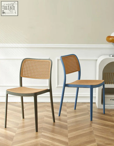 Two fanny dining chairs with woven cane seats and backs in matte gray and vibrant blue perfect for dining areas