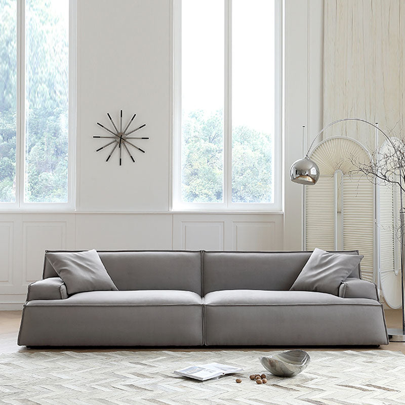 Gray upholstered fanny suede sectional sofa with clean lines and matching throw pillows in two to four seater options