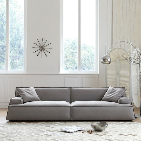 Gray upholstered fanny suede sectional sofa with clean lines and matching throw pillows in two to four seater options