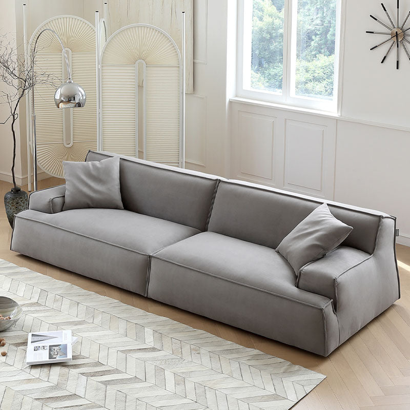 Modern gray suede fanny two seater sofa with clean lines and matching throw pillows for sleek living spaces