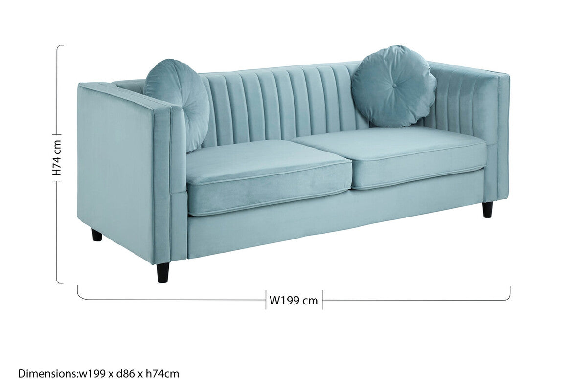 A pastel green velvet three seater sofa with tufted back panels and matching round throw pillows