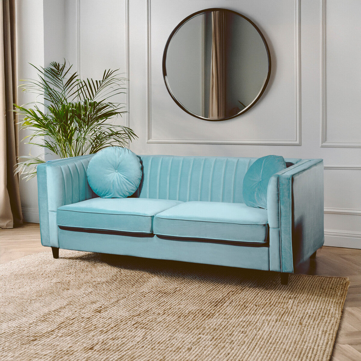 A pastel green velvet two-seater sofa with tufted back cushions and dark wooden legs perfect for cozy spaces