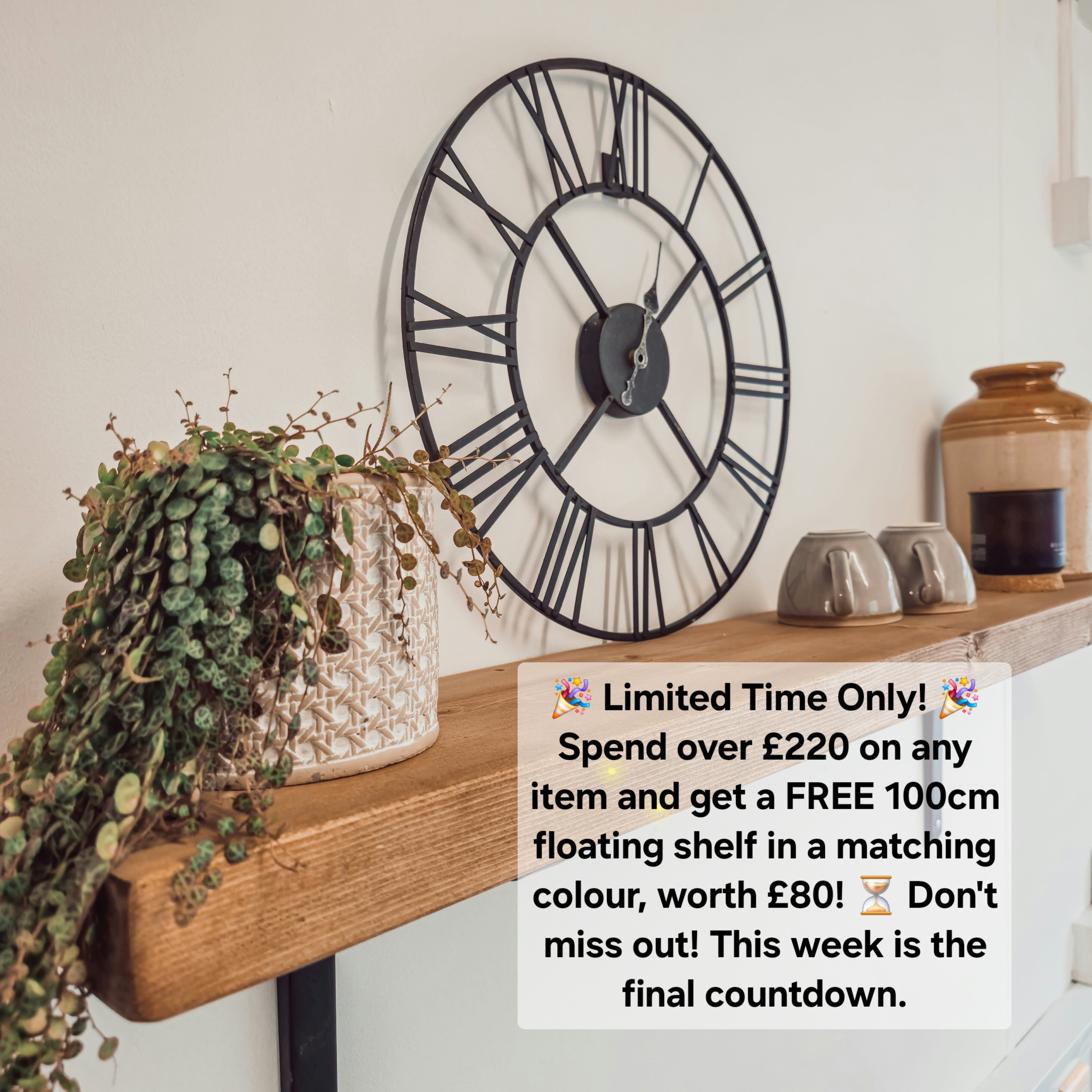 Black metal wall clock with roman numerals complements the pictured outdoor table with timber legs and bench setup