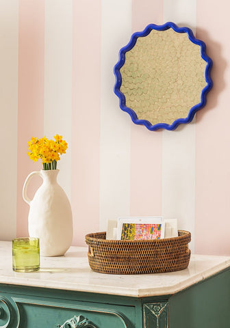 Blue scalloped edged mirror with textured gold reflective surface paired with farmhouse style clay jug