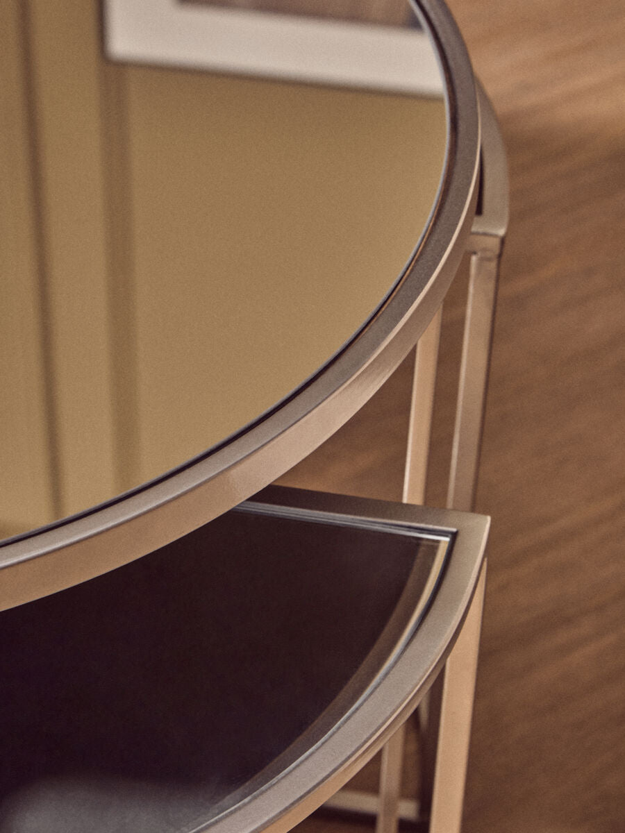 Circular mirrored tabletop with polished chrome frame and dark brown leather shelf from farran set silver finish tables